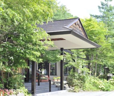 Wooden entrance canopy framed by lush greenery at Yumoto Itaya, Tochigi, Kantō