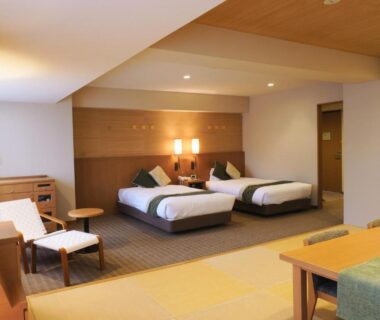 Tatami seating area and twin beds in Yumoto Noboribetsu guest room, Hokkaidō