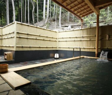 Covered outdoor onsen with bamboo fence and wooden water spout at Yumoto Onsen OharaSansou Kyoto