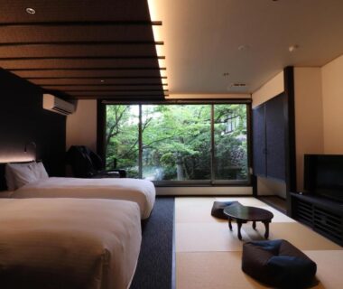 Tatami room with twin beds, low table and garden view at Yumoto Ueyama Hyōgo