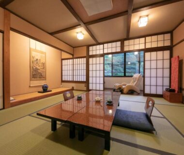 Traditional tatami room with low table, zabuton cushions, shoji screens and tokonoma overlooking a garden at Yumoto Ueyama, Hyōgo
