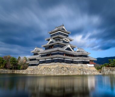 Multi-tiered Japanese castle with stone foundation and reflecting moat near Yumotoya in Nagano, Chūbu