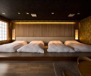 Raised wooden platform with four futon mattresses, shoji screen and warm lighting at Yumura Onsen MIDORIYA, Hyōgo