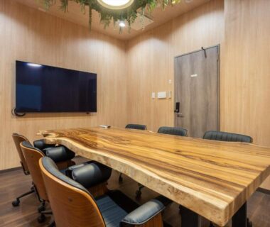 Meeting room with live-edge wooden table, wall-mounted TV and leather chairs at Yumura Onsen MIDORIYA, Hyōgo