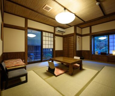 Traditional tatami room with low wooden table, floor cushions and shoji screens at Yunohira Kamiyanagiya in Ōita, Kyūshū