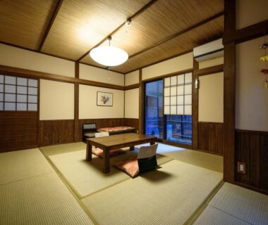 Tatami room with low table, floor cushions, shoji screens, and wooden paneling at Yunohira Kamiyanagiya, Ōita, Kyūshū