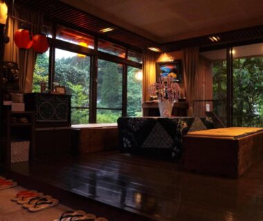 Cozy wooden lounge with low seating and garden view at Yunohira Kamiyanagiya, Ōita, Kyūshū