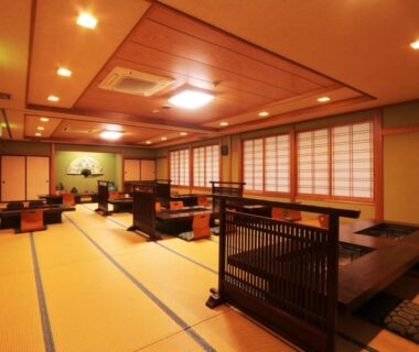 Spacious tatami dining room with low tables and shoji screens at Yunohirakan in Gifu