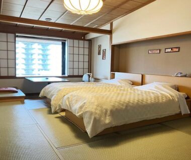 Tatami room with twin beds, low table by shoji window at Yunokawa Kanko Hotel Shoen in Hokkaidō
