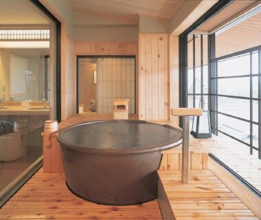 Round soaking tub on wooden deck with sliding doors in Yunokawa Kanko Hotel Shoen room, Hokkaidō