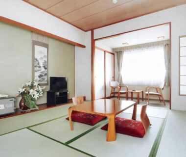 Traditional tatami room with low table, zabuton cushions, tokonoma alcove and sitting area at Yunokawa Kanko Hotel Shoen in Hokkaidō