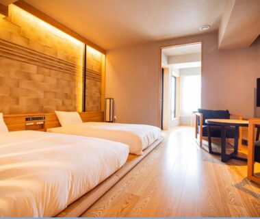 Twin beds on raised wooden platform with seating area and decorative wall panel at Yunokawa Prince Hotel Nagisatei Hokkaidō