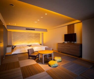 Modern tatami-style room with low table and bed at Yunokawa Prince Hotel Nagisatei in Hokkaidō, Japan