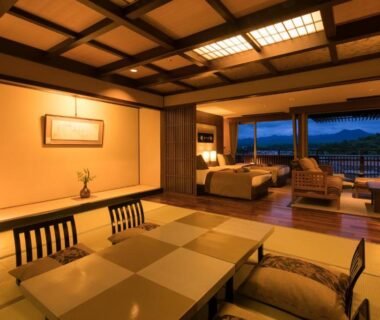 Tatami room with low dining table, shoji screens and seating area overlooking evening view at Yunokuni Tensyo, Ishikawa Chubu Japan