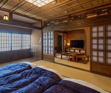 Traditional tatami room with futons, shoji screens and wooden ceiling at Yunoyado Irifune in Kumamoto
