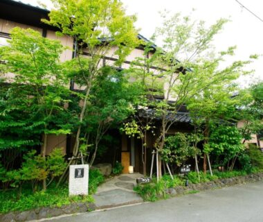 Lush green entrance and wooden façade of Yunoyado Irifune, Kumamoto, Kyūshū, Japan