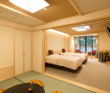 Spacious tatami area with two beds, low table, shoji screens and garden view at Yura No Yado Seifuen Nagano