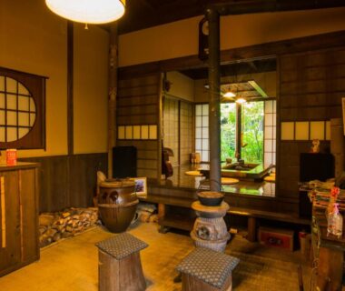 Interior of traditional tatami sitting area with low wooden stools and shoji screens at Yurari Rokumyo in Ōita