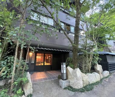 Entrance of Yusai Bekkan with wooden doorway, stone landscaping and trees in Kumamoto, Kyūshū, Japan