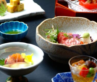 Assorted small Japanese dishes with sashimi and colorful appetizers presented on lacquerware at Yusakaso, Kanagawa