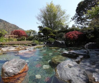 Stone-lined garden pond with clear water, rocks and trees at Yusakaso in Kanagawa