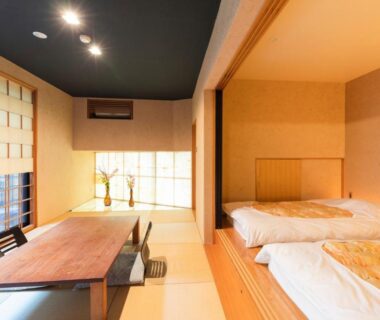 Traditional tatami room with futon bedding, low wooden table, zaisu chairs and shoji screens at Yushintei in Kanagawa