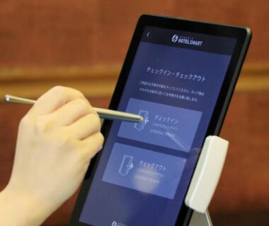 Hand using stylus on a check-in tablet at Yutorelo Nasushiobara reception, Tochigi