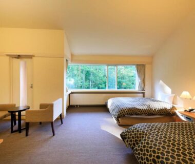 Bright twin bedroom with seating area at Yutorelo Tateshina Hotel in Nagano's Chūbu region
