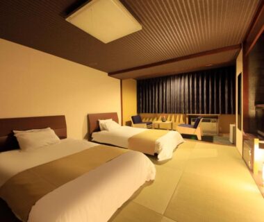 Spacious tatami room with two beds, low seating area and warm ambient lighting at Yutorelo Toyako, Hokkaidō