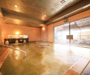 Indoor communal onsen with wooden interior and soaking pool at Yutorelo Toyako, Hokkaidō, Japan