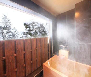 Steaming wooden tub on balcony overlooking snow at Yutorelo-an in Kanagawa, Kantō
