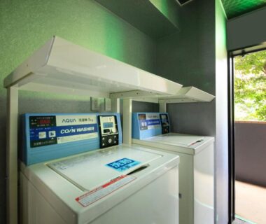 Top-loading coin-operated washers at Yutorelo-an ANNEX with balcony view of greenery, Kanagawa