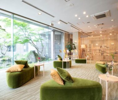 Spacious lobby seating with green sofas and courtyard garden at Yutoriro Bandai Atami in Fukushima, Tōhoku
