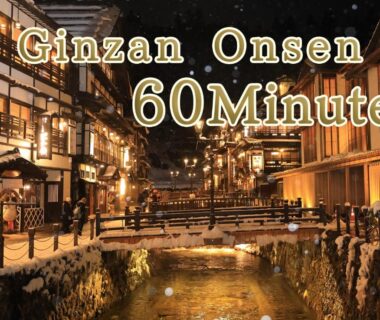 Illuminated wooden ryokan buildings along river, Yuuyu No Sato Yusa listing, Ginzan Onsen Yamagata