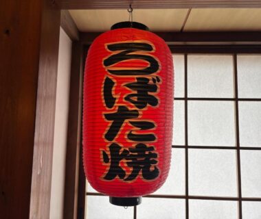 Hanging red paper lantern with Japanese characters beside shoji screens and wooden interior at Yuuzuru, Shizuoka