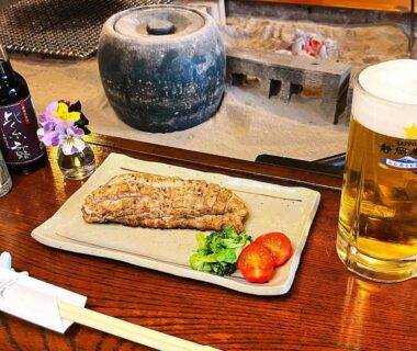 Grilled fish with vegetables and a beer beside a traditional irori hearth at Yuuzuru ryokan in Shizuoka