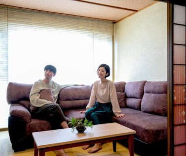 Couple seated on sofa in ryokan lounge with shoji screen and coffee table at Yuyado Ichibanchi, Shizuoka