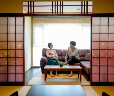 Two guests seated in tatami room with shoji screens and low table at Yuyado Ichibanchi, Shizuoka