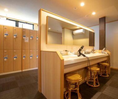 Dressing room with wooden lockers and vanity sinks at Yuyaruru Saisai, Ishikawa