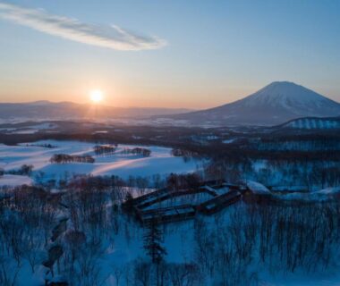Aerial view of snow-covered Zaborin grounds with distant mountain and sunrise in Hokkaidō