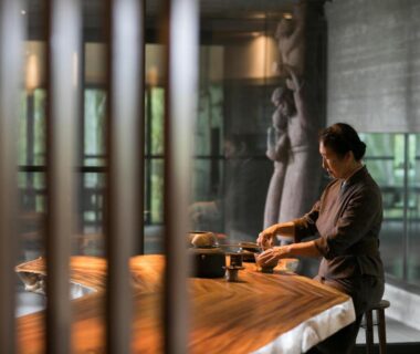 Staff preparing tea at a wooden counter in Zaborin lobby with sculpture and garden view