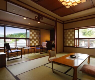 Tatami room with low table, zabuton cushions and shoji screens at Zao Onsen Omiya Ryokan in Yamagata