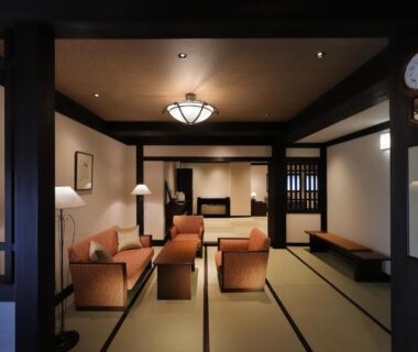 Traditional tatami sitting area with low sofas, shoji screens and wooden beams at Zao Onsen Omiya Ryokan, Yamagata