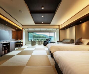 Spacious tatami-floored twin room with seating area and mountain view at Zao Shiki no Hotel, Yamagata