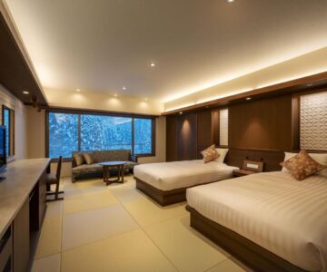 Spacious tatami-floored twin room with large window at Zao Shiki no Hotel, Yamagata
