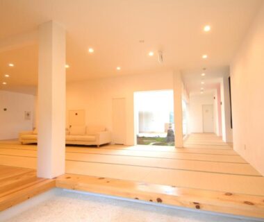 Bright tatami lounge with wooden step, sofas and corridor leading to a light-filled entrance at Zen no Yu Shizuoka Chūbu