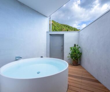 Circular outdoor soaking tub on wooden terrace with high walls, Zen no Yu, Shizuoka