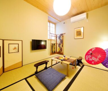 Tatami room with low table, zabuton cushions and decorative umbrellas at add-Hostel Uji Cha-gan-ju-tei Kyoto