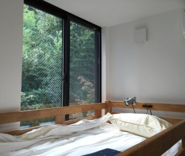 Wooden bunk bed with futon and large window overlooking greenery at add-Hostel Uji Cha-gan-ju-tei Kyoto