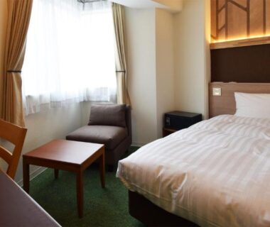 Single bed room with desk, armchair and window seating at adex Inn in Hokkaidō